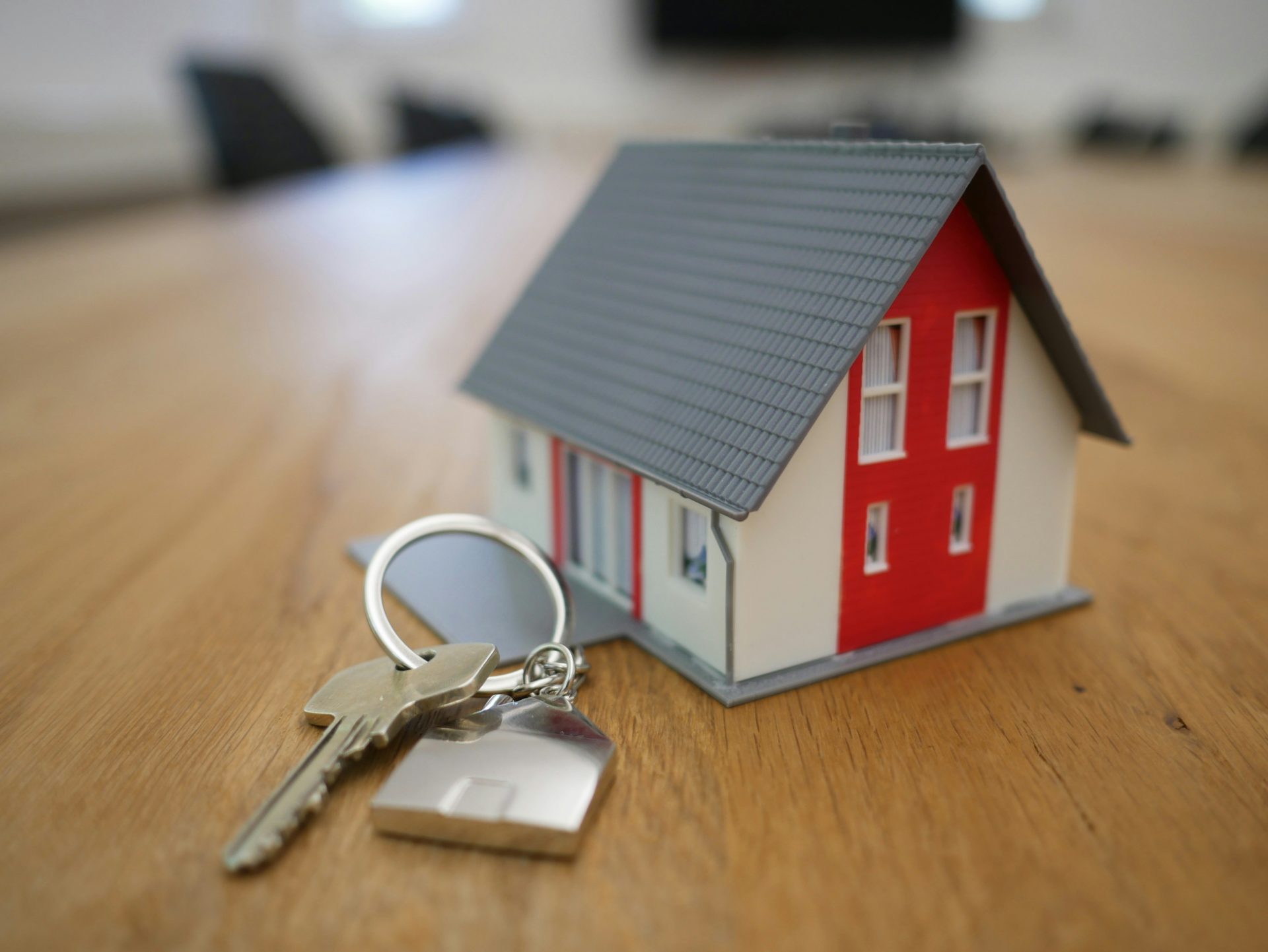 weiße und rote Holzhausminiatur auf braunem Tisch